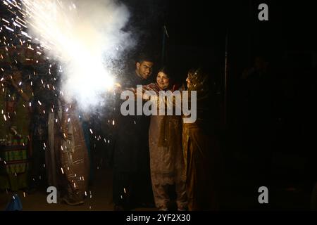 Hyderabad, Sindh, Pakistan. November 2024. Hindus Familie zündet während der Feier des Diwali Festivals in einem lokalen Tempel in Hyderabad einen Feuerwerkskörper an (Foto: © Jan Ali Laghari/Pacific Press via ZUMA Press Wire) NUR REDAKTIONELLE VERWENDUNG! Nicht für kommerzielle ZWECKE! Stockfoto