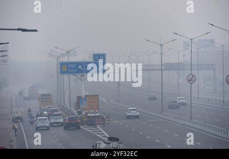 GHAZIABAD, INDIEN – 2. NOVEMBER: Fahrzeuge fahren auf einer Delhi Meerut Expressway-Straße bei schlechter Sicht aufgrund von Smog einen Tag nach den diwali-Festlichkeiten in Ghaziabad am frühen Morgen NH9 Lal kuan, am 2. November 2024 in Ghaziabad, Indien. Delhi NCR hat nach Diwali trotz eines Verbots von Feuerwerkskörpern einen starken Anstieg der Verschmutzungswerte verzeichnet. Die Luftqualität verschlechterte sich rapide, Delhi wurde als „sehr schlecht“ eingestuft. Städte wie Gurugram, Ghaziabad und Noida sind ebenfalls mit „sehr schlechten“ Bedingungen konfrontiert. Straßen, die mit Feuerwerkskörpern bedeckt sind, und giftiger Schaum auf dem Yamuna-Fluss erhöhen die gesundheitlichen Risiken. Gutschrift Stockfoto