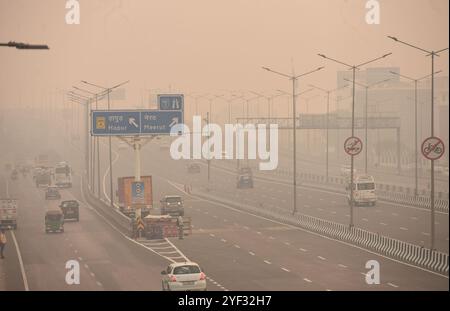 GHAZIABAD, INDIEN – 2. NOVEMBER: Fahrzeuge fahren auf einer Delhi Meerut Expressway-Straße bei schlechter Sicht aufgrund von Smog einen Tag nach den diwali-Festlichkeiten in Ghaziabad am frühen Morgen NH9 Lal kuan, am 2. November 2024 in Ghaziabad, Indien. Delhi NCR hat nach Diwali trotz eines Verbots von Feuerwerkskörpern einen starken Anstieg der Verschmutzungswerte verzeichnet. Die Luftqualität verschlechterte sich rapide, Delhi wurde als „sehr schlecht“ eingestuft. Städte wie Gurugram, Ghaziabad und Noida sind ebenfalls mit „sehr schlechten“ Bedingungen konfrontiert. Straßen, die mit Feuerwerkskörpern bedeckt sind, und giftiger Schaum auf dem Yamuna-Fluss erhöhen die gesundheitlichen Risiken. Gutschrift Stockfoto