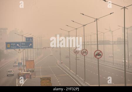 GHAZIABAD, INDIEN – 2. NOVEMBER: Fahrzeuge fahren auf einer Delhi Meerut Expressway-Straße bei schlechter Sicht aufgrund von Smog einen Tag nach den diwali-Festlichkeiten in Ghaziabad am frühen Morgen NH9 Lal kuan, am 2. November 2024 in Ghaziabad, Indien. Delhi NCR hat nach Diwali trotz eines Verbots von Feuerwerkskörpern einen starken Anstieg der Verschmutzungswerte verzeichnet. Die Luftqualität verschlechterte sich rapide, Delhi wurde als „sehr schlecht“ eingestuft. Städte wie Gurugram, Ghaziabad und Noida sind ebenfalls mit „sehr schlechten“ Bedingungen konfrontiert. Straßen, die mit Feuerwerkskörpern bedeckt sind, und giftiger Schaum auf dem Yamuna-Fluss erhöhen die gesundheitlichen Risiken. Gutschrift Stockfoto