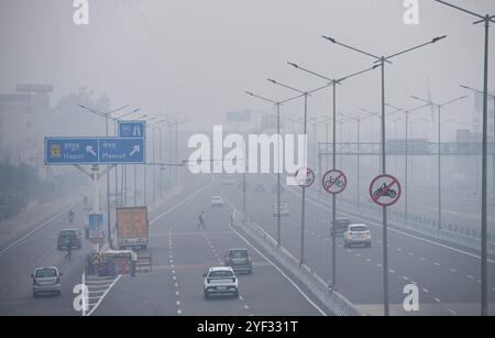 GHAZIABAD, INDIEN – 2. NOVEMBER: Fahrzeuge fahren auf einer Delhi Meerut Expressway-Straße bei schlechter Sicht aufgrund von Smog einen Tag nach den diwali-Festlichkeiten in Ghaziabad am frühen Morgen NH9 Lal kuan, am 2. November 2024 in Ghaziabad, Indien. Delhi NCR hat nach Diwali trotz eines Verbots von Feuerwerkskörpern einen starken Anstieg der Verschmutzungswerte verzeichnet. Die Luftqualität verschlechterte sich rapide, Delhi wurde als „sehr schlecht“ eingestuft. Städte wie Gurugram, Ghaziabad und Noida sind ebenfalls mit „sehr schlechten“ Bedingungen konfrontiert. Straßen, die mit Feuerwerkskörpern bedeckt sind, und giftiger Schaum auf dem Yamuna-Fluss erhöhen die gesundheitlichen Risiken. Gutschrift Stockfoto