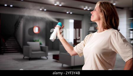 Frau Mit Air Spray Im Wohnzimmer Stockfoto