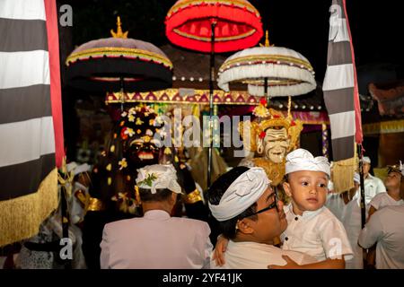 Ein Mann mit seinem Sohn Barong Landung Marionetten am Schrein, Kuningan Zeremonie, Pura Gunung Sari Tempel, Denpasar, Bali, Indonesien, Asien Stockfoto