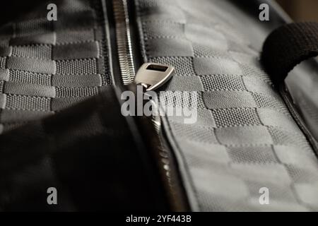 Tasche mit schwarz kariertem Kunstleder mit Reißverschluss in der Mitte als Hintergrund, schwarzer Lederhintergrund Stockfoto