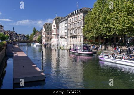 Straßburg - Ill Fluss mit Passagierbooten auf Höhe des Palais des Rohan mit großen Bäumen und traditionellen elsässischen Gebäuden im Hintergrund Stockfoto