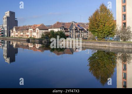 Nancy, Frankreich - der Marne-Rhein-Kanal mit einem alten Getreidesilo aus den 1940er Jahren, umgebaut in Wohngebäude und alte Häuser mit Reflexionen im Wasser. Stockfoto