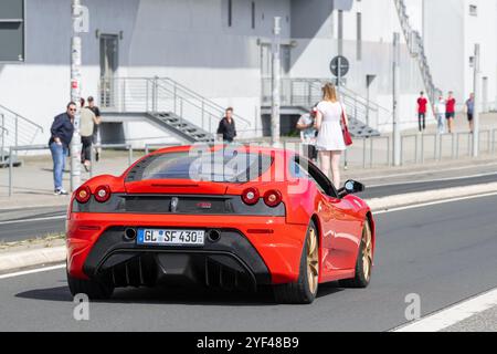 Nürburg, Deutschland - Blick auf einen roten Ferrari 430 Scuderia, der auf einer Straße fährt. Stockfoto