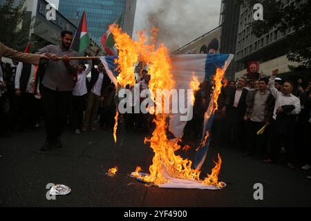 Teheran, Iran. November 2024. Die Iraner verbrennen eine Isrealflagge während einer Anti-US-Kundgebung zum 45. Jahrestag der Übernahme durch die US-Botschaft vor dem ehemaligen Botschaftsgebäude in Teheran. Am 4. November 1979 übernahmen iranische Studenten die US-Botschaft in Teheran und hielten über 50 amerikanische Diplomaten und Wärter 444 Tage lang als Geiseln. Und Israel nach Israels jüngstem Streik gegen den Iran. Quelle: ZUMA Press, Inc Quelle: ZUMA Press, Inc./Alamy Live News Stockfoto