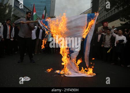 Teheran, Iran. November 2024. Die Iraner verbrennen eine Isrealflagge während einer Anti-US-Kundgebung zum 45. Jahrestag der Übernahme durch die US-Botschaft vor dem ehemaligen Botschaftsgebäude in Teheran. Am 4. November 1979 übernahmen iranische Studenten die US-Botschaft in Teheran und hielten über 50 amerikanische Diplomaten und Wärter 444 Tage lang als Geiseln. Und Israel nach Israels jüngstem Streik gegen den Iran. Quelle: ZUMA Press, Inc Quelle: ZUMA Press, Inc./Alamy Live News Stockfoto