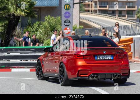 Monte Carlo, Monaco - Blick auf einen orangefarbenen BMW M3 F80 auf der Straße in der Fairmont Haarnadelkurve. Stockfoto