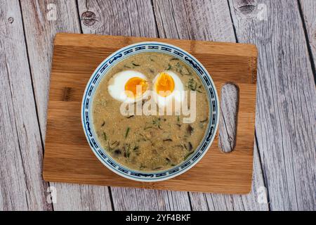 Das Bild zeigt eine Schüssel mit traditioneller tschechischer Kulajda-Suppe mit cremiger Textur mit sichtbaren Pilzstücken, Kartoffeln und einem pochierten Ei Stockfoto