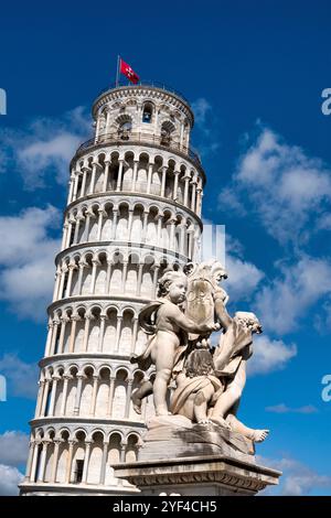 Zwei Cherubs aus dem „Fontana dei Putti“ halten einen Schild vor dem Schiefen Turm von Pisa, Italien. Stockfoto