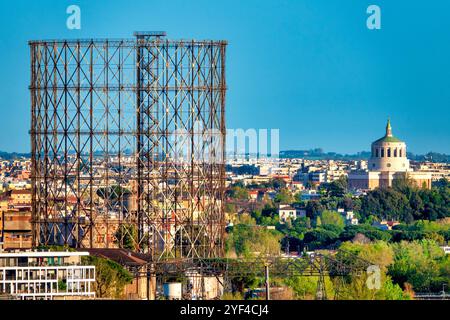 Blick auf den Gasometer mit der Kuppel der Chiesa di Santa Maria Regina degli Apostoli alla Montagnola im Hintergrund, Rom, Italien. Stockfoto