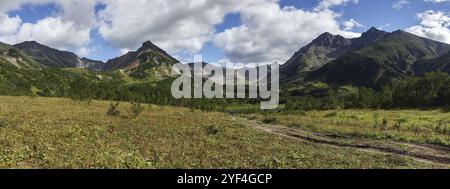 Wunderschönes Panorama Berglandschaft der Kamtschatka Halbinsel: Frühherbstblick auf die Bergkette Vachkazhets mit Waldhängen von Hügeln, Glade Gras Stockfoto