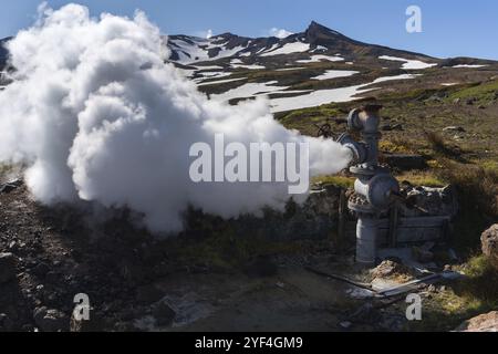 Emission von natürlichem Mineralthermalwasser, Dampf (Dampf-Wasser-Gemisch) aus geologischen Brunnen im geothermischen Ablagerungsgebiet, geothermischem Kraftwerk auf Steilhang Stockfoto