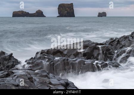 Wellen, Surfen, über Säulenbasalt gespült, Felsnadeln, lange Exposition, Dyrholafjara, Felsentor Dyrholaey oder Dyrholaey, Südküste, Island, Europa Stockfoto