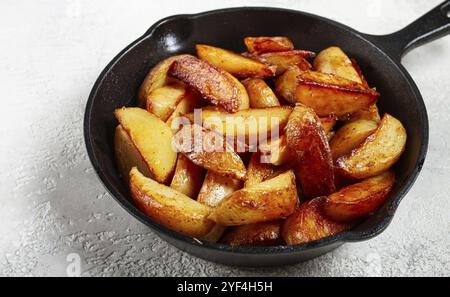 Gebratene Kartoffelscheiben, in einer gusseisernen Pfanne, selbstgemacht, keine Leute Stockfoto