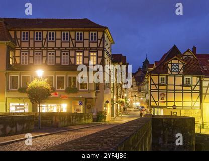 Die lange Straße in der Altstadt von Hannoversch Muenden mit Fachwerkhäusern am Abend. Die alte Werrabrücke im Vordergrund. Hann Stockfoto