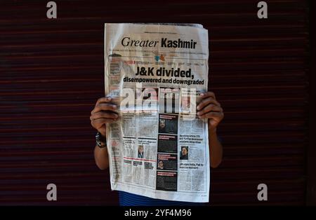 Srinagar, Kaschmir. August 2019. Eine Kasmiri-Zeitung berichtet über die Schlagzeile „J&K geteilt“, während im indischen Kaschmir eine Ausgangssperre verhängt wird. Die Ausgangssperre wurde seit dem 5. August umgesetzt, nachdem die indische Regierung Artikel 370 gestrichen hatte, der dem Staat Jammu und Kaschmir einen Sonderstatus einräumte. Die Ausgangssperre wurde in Jammu und Kaschmir eingeführt, um jegliche Proteste zu unterbinden. Alle Kommunikationskanäle wurden im Kaschmir-Tal blockiert Stockfoto