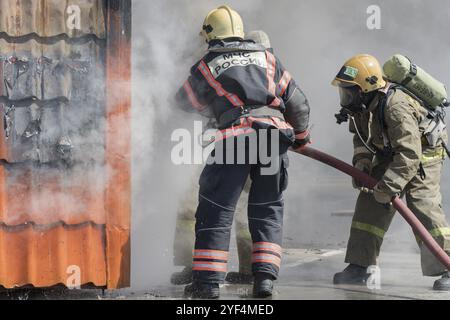 Feuerwehrleute Löschfeuer aus Löschschlauch, mit Brandbekämpfung Wasser-Schaum-Fass mit Luft-mechanischen Schaum während der professionellen Urlaub Feuerwehrleute Stockfoto