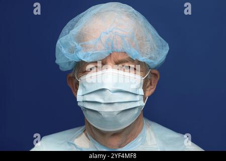 Porträt eines älteren Erwachsenen in chirurgischer Gesichtsmaske mit Ohrbügeln, bedeckt Nase und Mund von SARS, virulent infektiöse Krankheit Corona Virus. Stockfoto