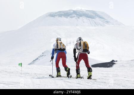 KORYAK, AVACHA VOLCANOES, KAMCHATKA, RUSSLAND, 27. APRIL, 2014: Skibergsteiger des Teams klettern auf Skiern auf dem Vulkan Avachinsky. Team Race Skitouren Stockfoto