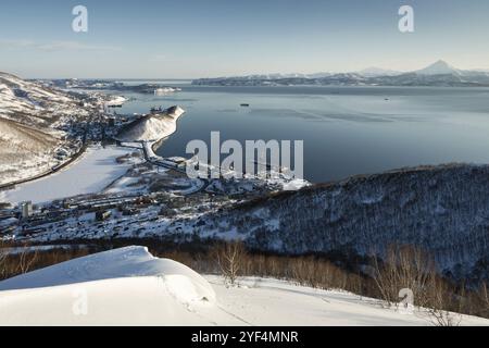 Wunderschöne Winter-Kamtschatka-Landschaft: Top-Panoramablick auf die Stadt Petropavlovsk-Kamtschatski, die Bucht von Avachinskaya und den Pazifischen Ozean bei Sonnenuntergang. Russland, F Stockfoto