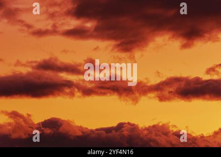 Orange Wolken glühend von verschwindenden Strahlen bei Sonnenuntergang schwimmend über gelb Himmel. Sommer tolle Aussicht auf skyscape, natürliche Meteorologie Hintergrund. Weich Stockfoto