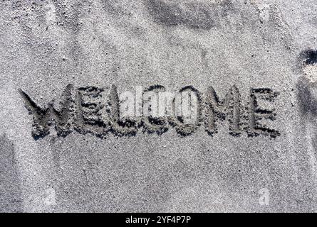 Business Hello and Welcome Konzept. Konzeptwort Willkommen geschrieben am wunderschönen Sandstrand des Ozeans. Wunderschöner Ozean Sandstrand Hintergrund, Kopierraum. Bus Stockfoto