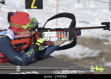 Sportsfrau Biathlet zielen, Gewehrschießen, Nachladen der Bauchlage. Kasachstans Biathletin Polina Yegorova im Schießstand. Junior-Biathlon-Wettkampf Stockfoto