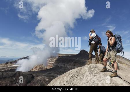 KAMTSCHATKA-HALBINSEL, RUSSISCHER FERNOST, 21. JULI 2013: Gruppe von Touristen im Krater des aktiven Vulkans Gorely macht ein Bild von vulkanischem Krater, Krater lak Stockfoto