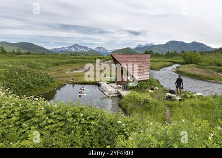 NALYCHEVO, KAMTSCHATKA HALBINSEL, RUSSLAND, 11. JULI 2014: Gorjatschenski Gruppe heiße Quellen im Naturpark Nalytschevo, Touristen schwimmen in der Natur Stockfoto