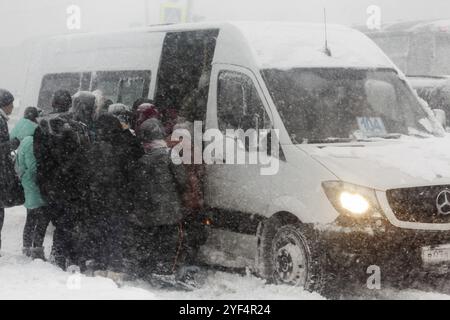 STADT PETROPAVLOVSK, HALBINSEL KAMTSCHATKA, RUSSLAND, 26. Dezember 2017: Das Leben in der Stadt im Winter bei starkem Schneesturm, Schneesturm, Passagiere, die an der Bushaltestelle einsteigen Stockfoto