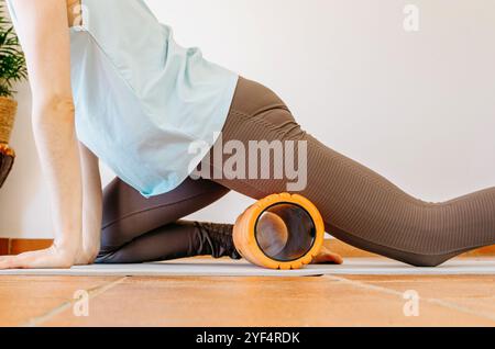 Quadrizeps-Selbstmyofaszienfreisetzung mit Schaumwalze Stockfoto