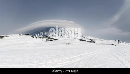 Winterliche Panorama-Berglandschaft von Kamtschatka: Blick auf den aktiven Korjaksky-Vulkan und wunderschöne Wolken bei bewölktem Wetter. Kamtschatka Halbinsel, Far Ea Stockfoto