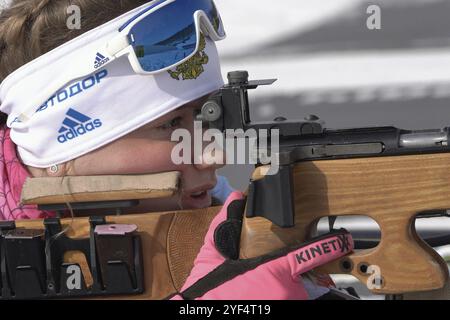 Sportsfrau Biathletin zielend, Gewehrschießen Stehposition. Biathlet Vlada Shishkina Sankt Petersburg auf dem Schießstand. Junior-Biathlon-Wettkampf Stockfoto