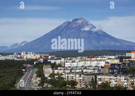 Stadtlandschaft von Petropavlovsk-Kamtschatski Stadt: Städtische Entwicklung, Wohngebäude auf dem Hintergrund des schönen aktiven Korjak-Vulkans auf sonniger da Stockfoto
