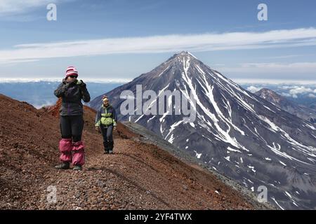 AVACHA VULKAN, KAMTSCHATKA HALBINSEL, RUSSLAND, 7. August 2014: Zwei junge Frauen wandern auf einem Bergwanderweg am Rand des Kraters von Acti Stockfoto