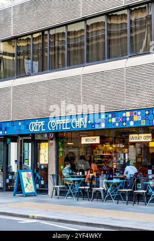 Außerhalb des Crêpes, Coffee and Chai Café in der Tottenham Hourt Road im St. Giles Hotel brutalistisches Gebäude, London, England Stockfoto