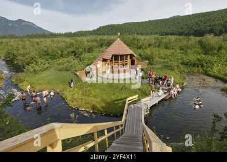 NALYCHEVO, KAMTSCHATKA, RUSSLAND, 11. JULI 2014: Gorjacherechenski Gruppe heiße Quellen im Naturpark Nalytschevo, Touristen schwimmen in der natürlichen Thermalquelle po Stockfoto