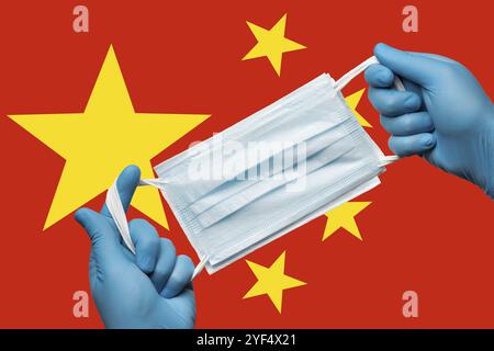 Medic hält Atemschutzmaske in Händen in blauen Handschuhen auf Hintergrundflagge der Volksrepublik China PRC. Konzept Coronavirus-Quarantäne, Grip Stockfoto