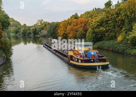 Transportindustrie. Ein Schiff transportiert Metallschrott und Sand mit Kies. Ein mit Metallschrott beladener Kahn ist auf der Straße. Metallschrott Stockfoto