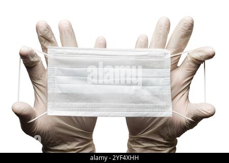Arzt hält Chirurgie medizinische Gesichtsmaske in den Händen in Handschuhen isoliert auf weißem Hintergrund. Medizinische Konzept Schutzkleidung, Ausrüstung während coro Stockfoto
