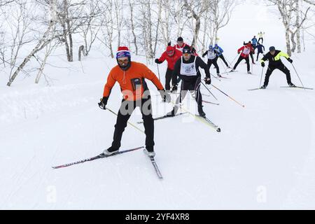 PETROPAVLOVSK STADT, KAMTSCHATKA HALBINSEL, RUSSISCHER FERNOST, 10. FEBRUAR 2018: Skifahrer laufen auf Skipisten im Winterwald. Gesamtrussische Massenskirennen, Stockfoto