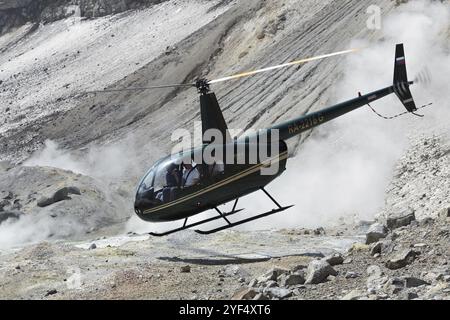 MUTNOVSKY VULKAN, KAMTSCHATKA, RUSSLAND, 4. JULI 2014: Blick auf den touristischen Hubschrauber Robinson R44 Raven mit Touristen und Reisenden an Bord startet Stockfoto