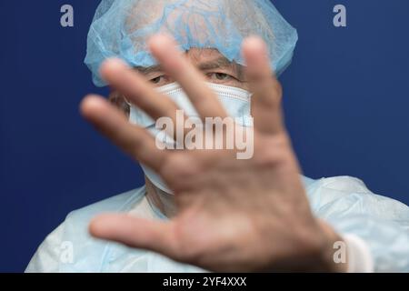 Porträt eines älteren Erwachsenen mit medizinischer Gesichtsmaske, die Nase und Mund von SARS bedeckt, 2019-ncov-Infektion. Der Mann bedeckt das Gesicht mit der Hand, Protectin Stockfoto