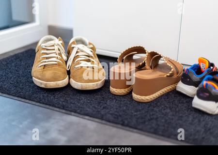 Schuhfamilie, Vater, Mutter und Kinderschuh. Sneaker, Braune Sandalen, Kinder Sneaker. Hochwertige Fotos Stockfoto