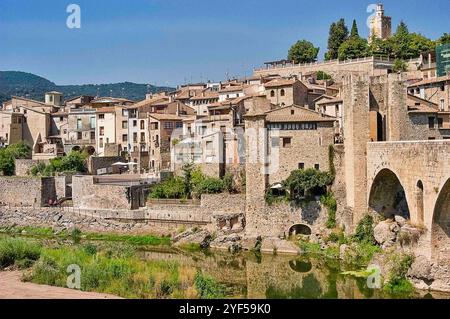 Besalu;Spanien;03302018: Malerischer Blick auf eine historische Stadt mit Steinhäusern und einer großen Bogenbrücke über einen Fluss. Die Stadt liegt auf einem Hügel Stockfoto