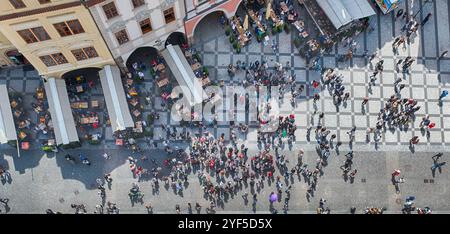 PRAG - 10. MAI 2024: Touristen wandern auf dem Altstadtplatz in Prag, Tschechien, mit seinen kopfsteingepflasterten Straßen und farbenfrohen Gebäuden Stockfoto
