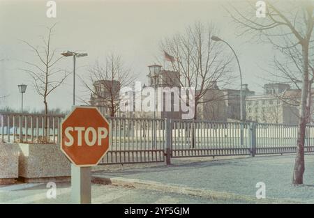 Berlin, Deutschland. Ca 1986. Ein rotes Stoppschild und ein Zaun laufen rund drei Jahre vor dem Fall der Berliner Mauer im Jahr 1989 entlang des Pariser Platzes. Im Buchengelände ist das Reichstag-Gebäude in West-Berlin mit dem Berliner Fall vor dem Berliner Reichstag zu sehen. Archivbild aufgenommen ca. 1986 Stockfoto